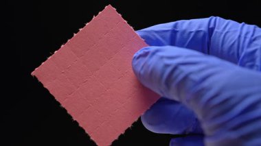 LSD Psychedelics terapisi ve Lysergic asit deneyleri. Halüsinojenik ilaç oral tüketim ve akıl sağlığı. LSD 'li adam kendini tedavi ederken kuru liserjik asit damlaları ile şeritleri tutuyor..