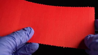 Eldivenli uyuşturucu satıcısının elleri, LSD şerit kağıtlarını kuru Lysergic asit damlalarıyla kırıyor ya da yırtıyor. Lucy veya Ellis D. Halüsinojenik uyuşturucu kulüplerde, partilerde ve sokaklarda satılıyor..