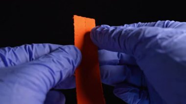 Eldivenli uyuşturucu satıcısının elleri, LSD şerit kağıtlarını kuru Lysergic asit damlalarıyla kırıyor ya da yırtıyor. Lucy veya Ellis D. Halüsinojenik uyuşturucu kulüplerde, partilerde ve sokaklarda satılıyor..