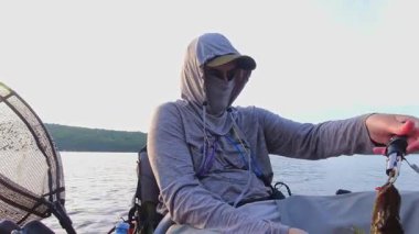 Kano balıkçılığı, insanlar taze balık avlıyor Ontario, Kanada 'daki Simcoe Gölü' nde, alacakaranlık doğası ve sükunetinde. Angler sıcak yaz akşamlarında yalnızlığın tadını çıkarır..