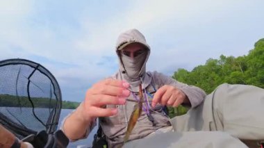 Kano sporu balıkçılığı. Angler kanoyla sahili gezmeyi seviyor, oltasını atıp sersemletiyor. Huzurlu su kıyısı ve Simcoe Gölü, Ontario, Kanada 'da mükemmel bir ortam. Yakala ve bırak..