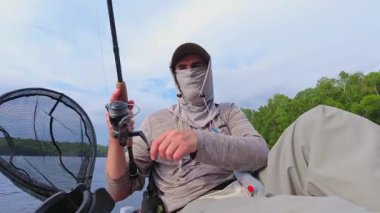 Kano sporu balıkçılığı. Angler kanoyla sahili gezmeyi seviyor, oltasını atıp sersemletiyor. Huzurlu su kıyısı ve Simcoe Gölü, Ontario, Kanada 'da mükemmel bir ortam. Yakala ve bırak..