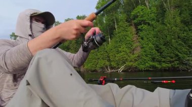Kano sporu balıkçılığı. Angler kanoyla sahili gezmeyi seviyor, oltasını atıp sersemletiyor. Huzurlu su kıyısı ve Simcoe Gölü, Ontario, Kanada 'da mükemmel bir ortam. Yakala ve bırak..
