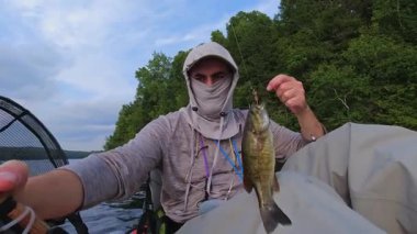 Kano sporu balıkçılığı. Angler kanoyla sahili gezmeyi seviyor, oltasını atıp sersemletiyor. Huzurlu su kıyısı ve Simcoe Gölü, Ontario, Kanada 'da mükemmel bir ortam. Yakala ve bırak..