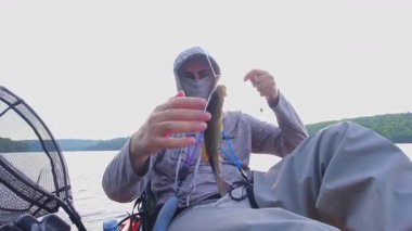 Kanada 'nın Ontario kentindeki Simcoe gölünde baş döndürücü doğa ve sükunetle çevrili kano balıkçılığı yalnızlığı. Angler sıcak yaz akşamlarında yalnızlıktan hoşlanır. İnsan oltasını atar ve sarar..