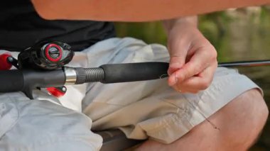 Balıkçı hobisi, metal lideri büyük levrek, balık yemi ya da yem için örgü örüyor. Spor balıkçılığı, adam tatilde balık tutmayı seviyor..