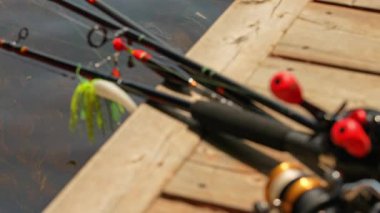 Balıkçı oltalarına, kordonlara ve küçük balıkların yemlerine odaklan. Tekne evinin yakınındaki tekne iskelesinde olta ve olta ile olta atma. Ağır çekim. Çocuklarla aile balıkçılığı.