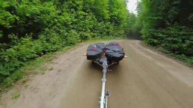 Kayık römorkunda su geçirmez ultraviyole koruma kumaşlarıyla kaplı kanolar, kamyon veya arabayla taşınıyor. Su sporu balıkçılığı. Gölde tekne denize açılacak. Römork balıkçılığı kanoları.