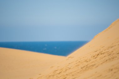 Sarı kum ve mavi deniz ve gökyüzü