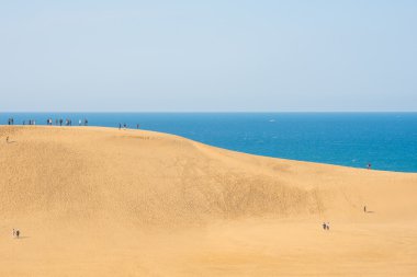 Sarı kum ve mavi deniz ve gökyüzü