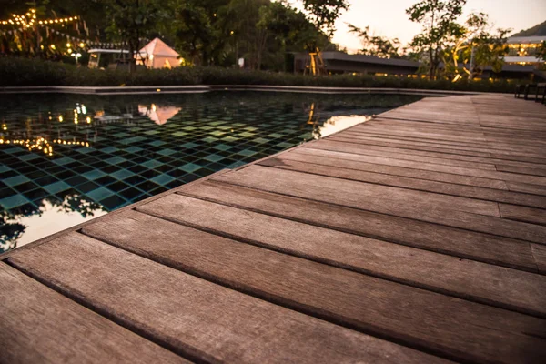 Terraza de madera de la piscina por la noche — Foto de Stock