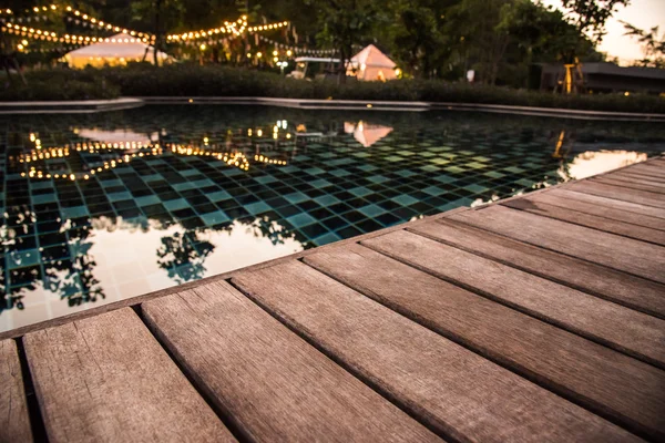 Terraza de madera de la piscina por la noche — Foto de Stock