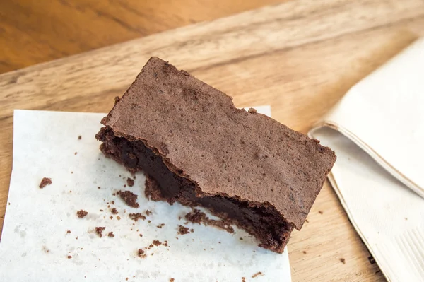 Brownie au chocolat délicieux mordu sur un plateau en bois — Photo