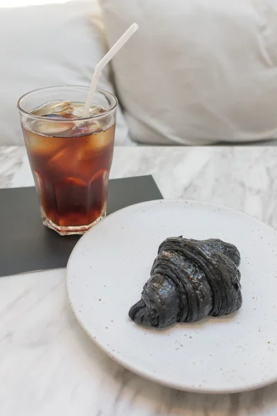 Iskallt kaffe och svart färg croissant — Stockfoto