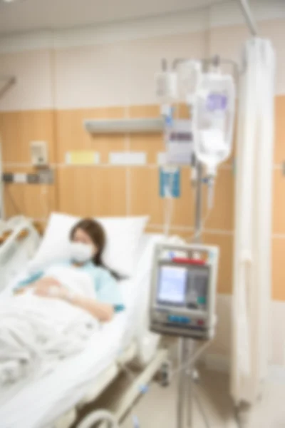 Foto desenfocada de la enfermedad de la mujer en la cama en la habitación del hospital —  Fotos de Stock