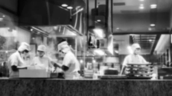 Blurred background black and white photo of chefs cooking in  op