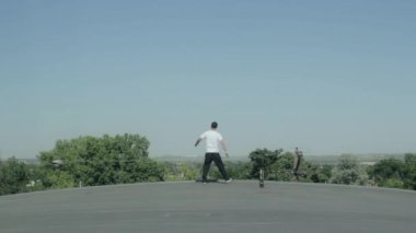 Genç adam çalışır ve manzaraya bakan çatı üzerinde durur