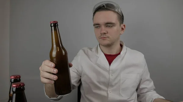 Genç bir bira üreticisi ürünleri hazırlar ve ekipmanların kalitesini ve evde demlenen ballı biranın kalitesini kontrol eder.