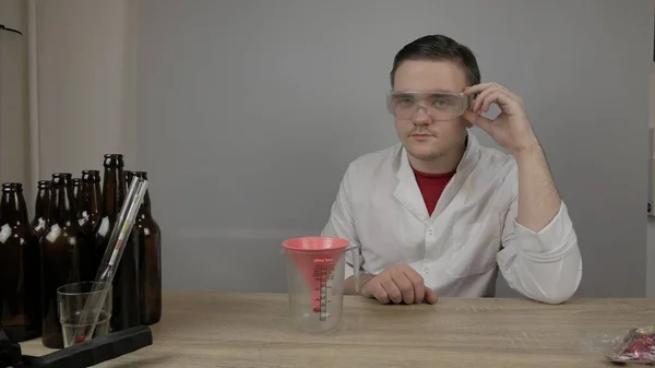 Genç bir bira üreticisi ürünleri hazırlar ve ekipmanların kalitesini ve evde demlenen ballı biranın kalitesini kontrol eder.