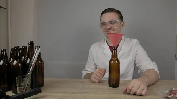 Genç bir bira üreticisi ürünleri hazırlar ve ekipmanların kalitesini ve evde demlenen ballı biranın kalitesini kontrol eder.