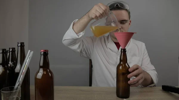 Genç bir bira üreticisi ürünleri hazırlar ve ekipmanların kalitesini ve evde demlenen ballı biranın kalitesini kontrol eder.