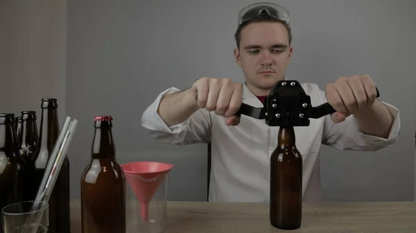 Genç bir bira üreticisi ürünleri hazırlar ve ekipmanların kalitesini ve evde demlenen ballı biranın kalitesini kontrol eder.