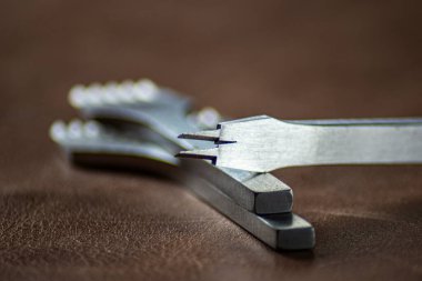 Deriyle çalışmak için metal yumruklar deri arka plan makrosu bulanıklaştırır