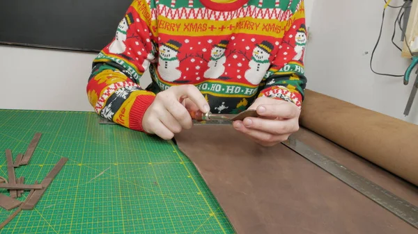 Deri ustası, deriyle çalışıyor.