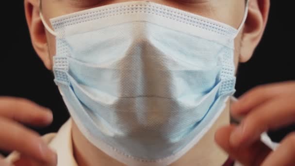 Cara Manto Médico Branco Uma Máscara Médica Azul Fundo Escuro — Vídeo de Stock