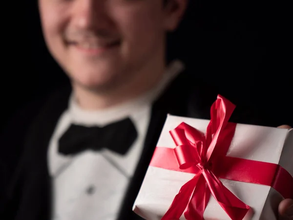 Giovane Ragazzo Abito Nero Shirt Mostra Regalo Bianco Uno Sfondo — Foto Stock