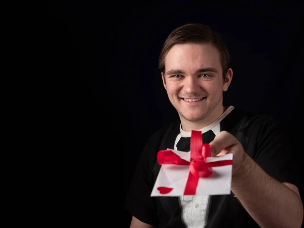 Joven Traje Camiseta Negro Extiende Mano Con Una Postal Blanca — Foto de Stock