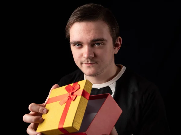 Joven Con Traje Camiseta Negro Abre Regalo Amarillo Rojo Sobre — Foto de Stock