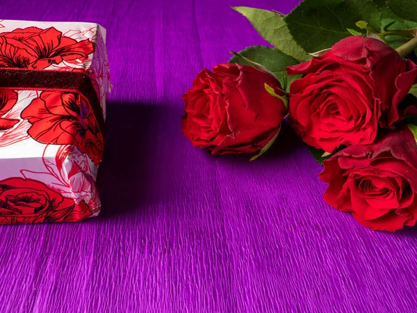 Rose Rosse Con Regalo Rosso Sfondo Viola — Foto Stock