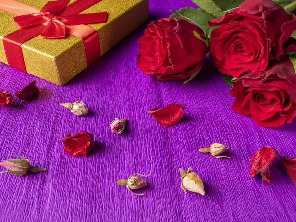 Rose Rosse Accanto Regalo Giallo Boccioli Rosa Sfondo Viola — Foto Stock