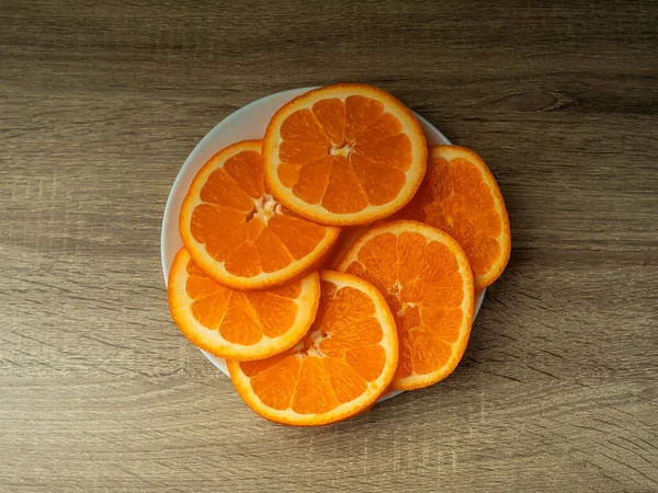 Koyu bir zemin üzerinde ahşap gri bir masada portakal dilimleri Taze meyve suyu konsepti