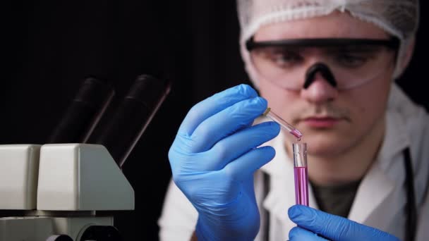 Młoda Asystentka Laboratoryjna Wlewa Różowy Płyn Szklanej Kolby Pipetą Asystent — Wideo stockowe