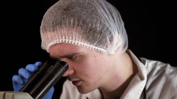 Νεαρός Βοηθός Εργαστηρίου Κοιτάζει Μέσα Από Ένα Μικροσκόπιο Τότε Βλέποντας — Αρχείο Βίντεο