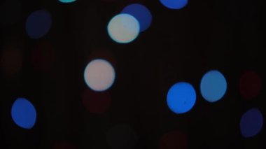 Siyah arka planda yavaş yavaş yanıp sönen bulanık noel ağacı ışığının Bokeh çekimi. Görüntü ve arkaplan kavramı
