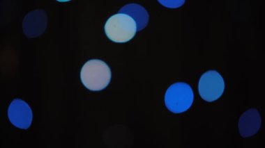 Siyah arka planda yavaş yavaş yanıp sönen bulanık noel ağacı ışığının Bokeh çekimi. Görüntü ve arkaplan kavramı