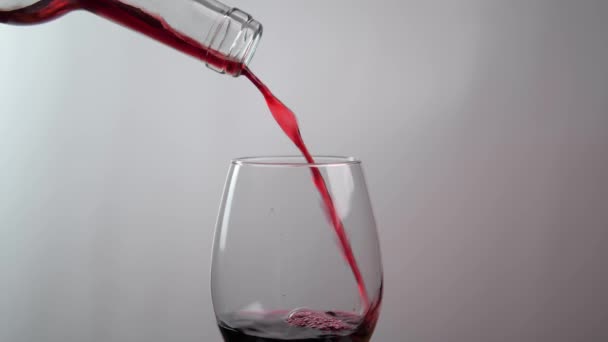 白を基調としたガラスに瓶から注がれる赤ワインのクローズアップ アルコールの概念 — ストック動画