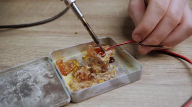 preparation of copper wires for connection with a metal hot soldering iron. soldering iron and electronics repair concept