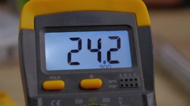 measurement of 24 watt current close-up. the concept of measuring voltage with a multimeter that is black