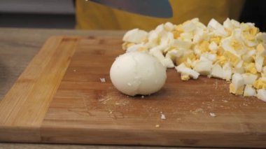 Boiled eggs, slicing and preparing eggs for making Olivier salad, salad making concept, food from the restaurant