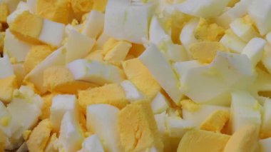 Boiled eggs, slicing and preparing eggs for making Olivier salad, salad making concept, food from the restaurant