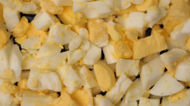 Boiled eggs, slicing and preparing eggs for making Olivier salad, salad making concept, food from the restaurant