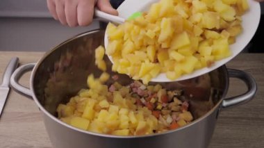 Boiled potatoes, cutting and preparing potatoes for kneading into Olivier salad, the concept of preparing a salad, food from the restaurant