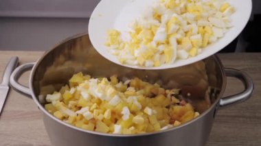 Boiled eggs, slicing and preparing eggs for making Olivier salad, salad making concept, food from the restaurant