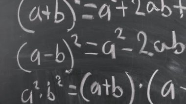 Kara tahtaya yazılmış matematiksel denklemlerin yakın çekimi. Okul kavramı