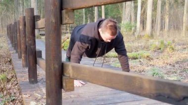 Siyah eşofmanlı adam kahverengi bir köprüde yerden kalkıyor. Sağlıklı yaşam tarzı kavramı