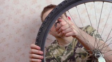 Adam bisikletin tekerleğini tamir ediyor, direksiyondaki telleri sıkılaştırıyor. Bisiklet tamir konsepti